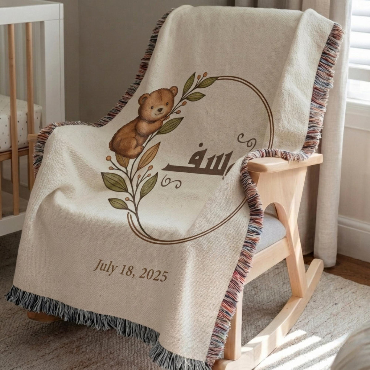 Personalized baby blanket with a botanical teddy bear and Arabic name, resting on a wooden rocking chair in a nursery near a white crib.