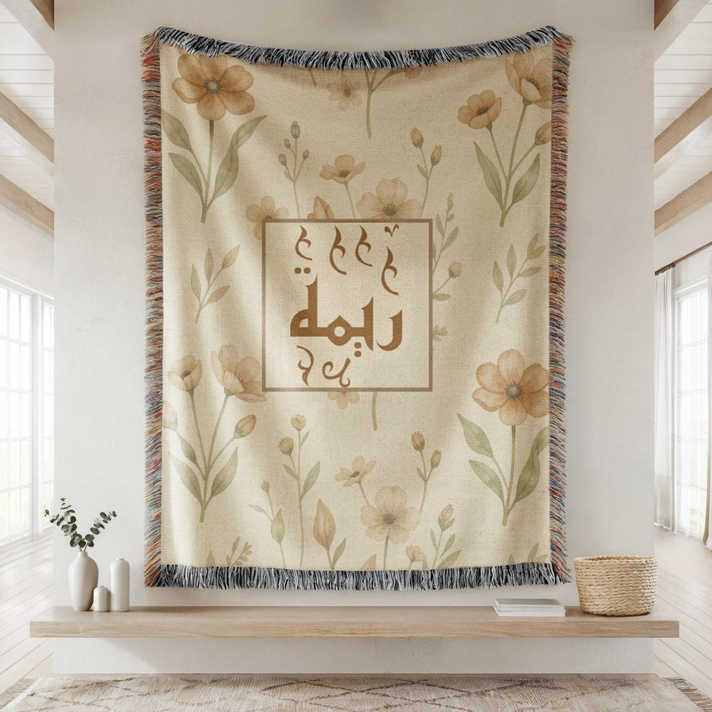 Classic Framed Arabic Calligraphy blanket hanging against a plain wall with a fringed border, displayed above a wooden shelf with plant decor, highlighting the full design.