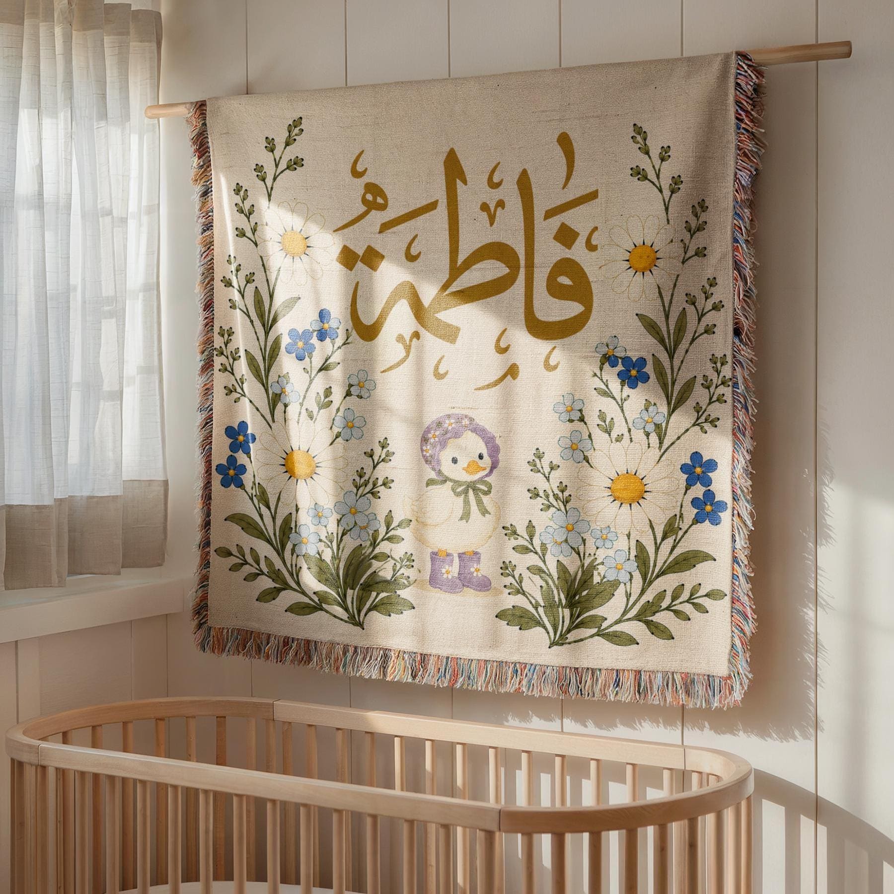 Personalized Arabic Name Blanket on display as a decorative tapestry above a wooden crib in a brightly lit nursery, highlighting the botanical design and tasseled fringe.