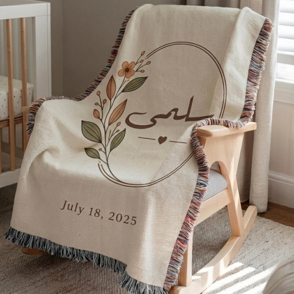 Close-up of the "Botanical" personalized blanket's tasseled fringe, draped over a wooden rocking chair, highlighting the floral design and date.
