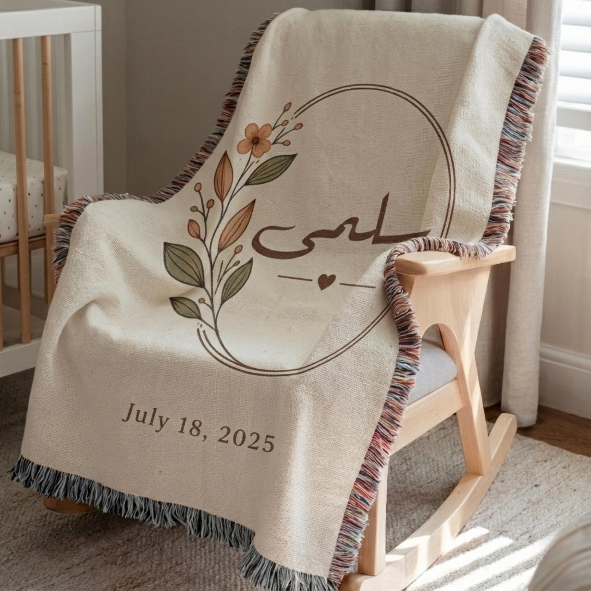 Close-up of the "Botanical" personalized blanket's tasseled fringe, draped over a wooden rocking chair, highlighting the floral design and date.