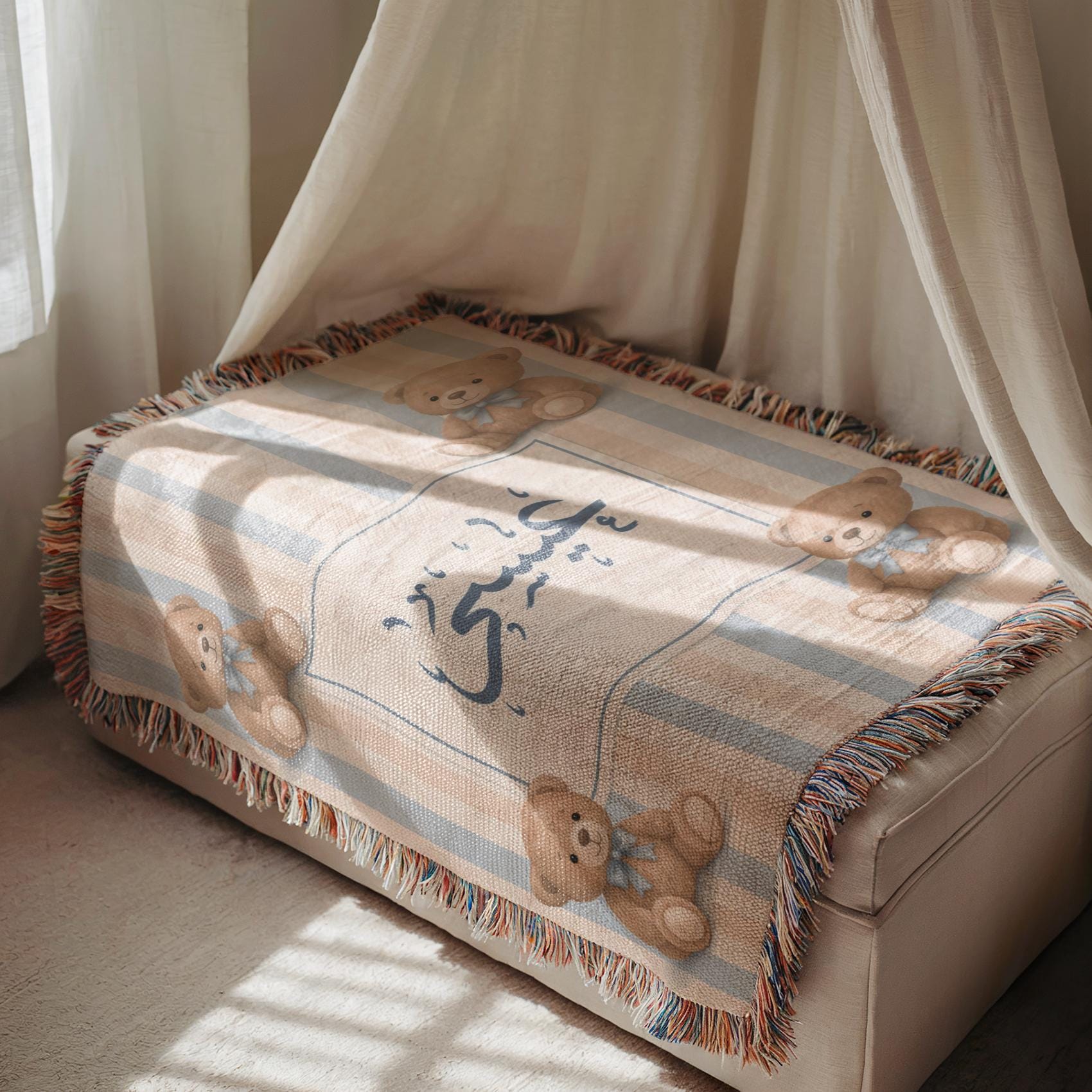 Striped bear patterned baby blanket with custom Arabic name, draped over a padded bench in a softly lit room, highlighting its tasseled fringe and layered appearance.