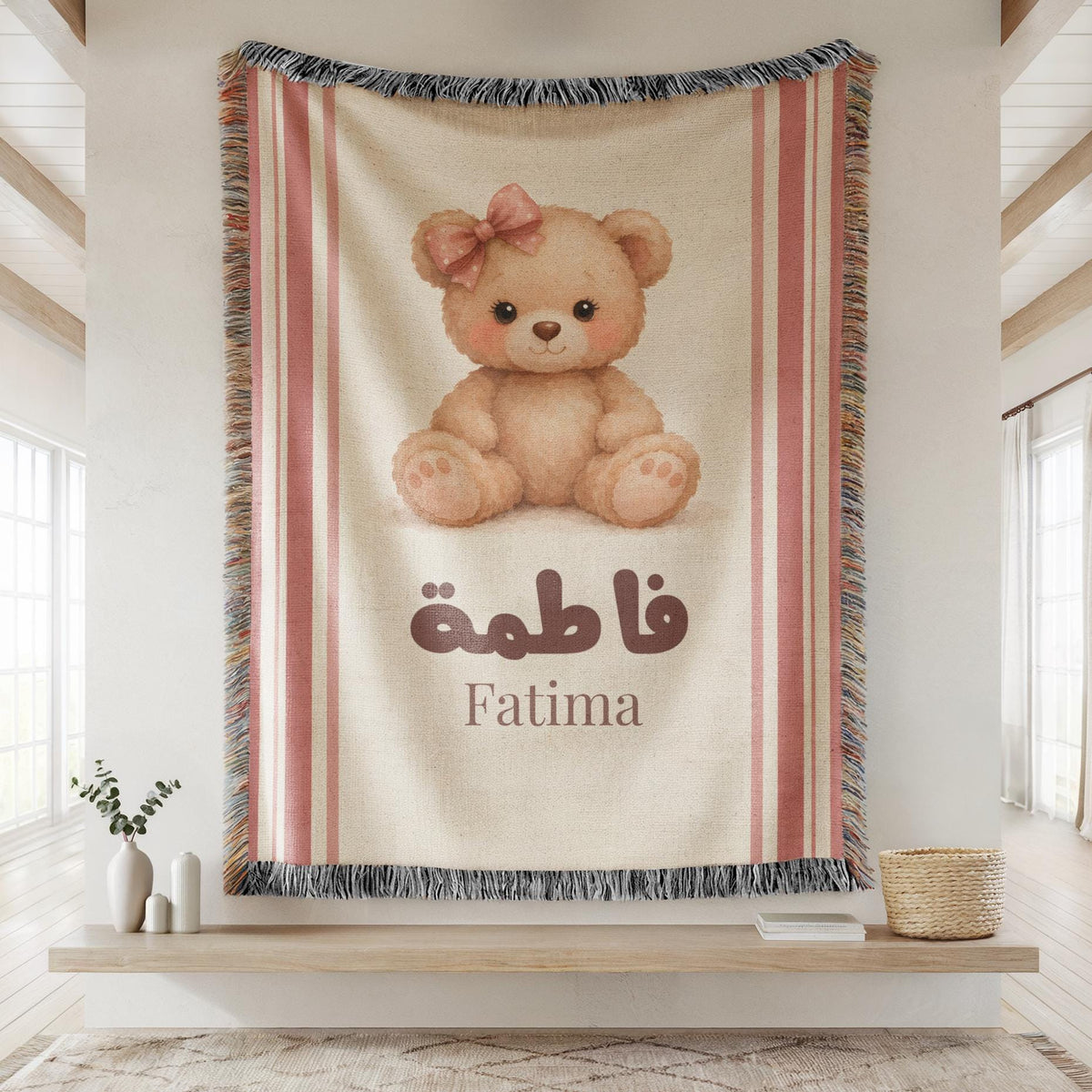 Close-up of the "Vintage Bear" personalized blanket's woven texture, hanging flat against a wall, showing the teddy bear illustration, custom name, and fringed edges.
